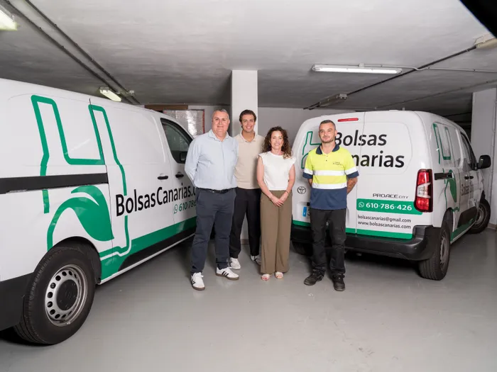 Equipo de Bolsas Canarias junto a las furgonetas de reparto en el almacén de Puerto de la Cruz